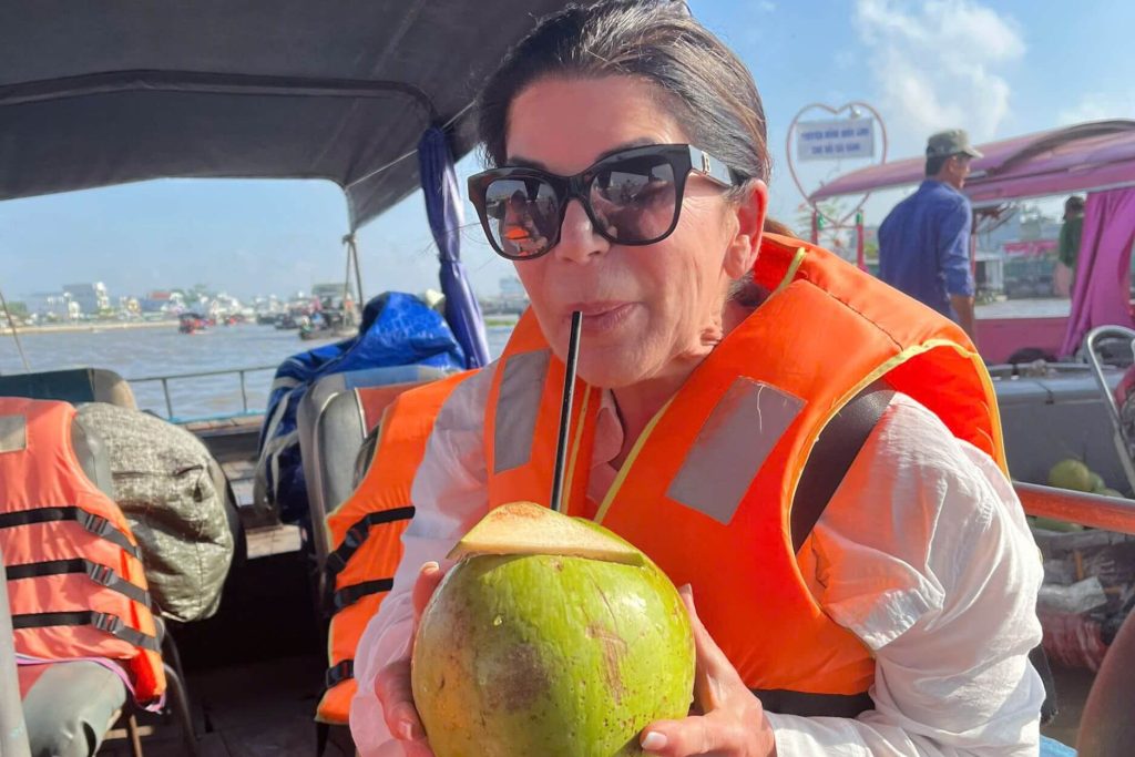 woman drinking coconut water in saigon tours