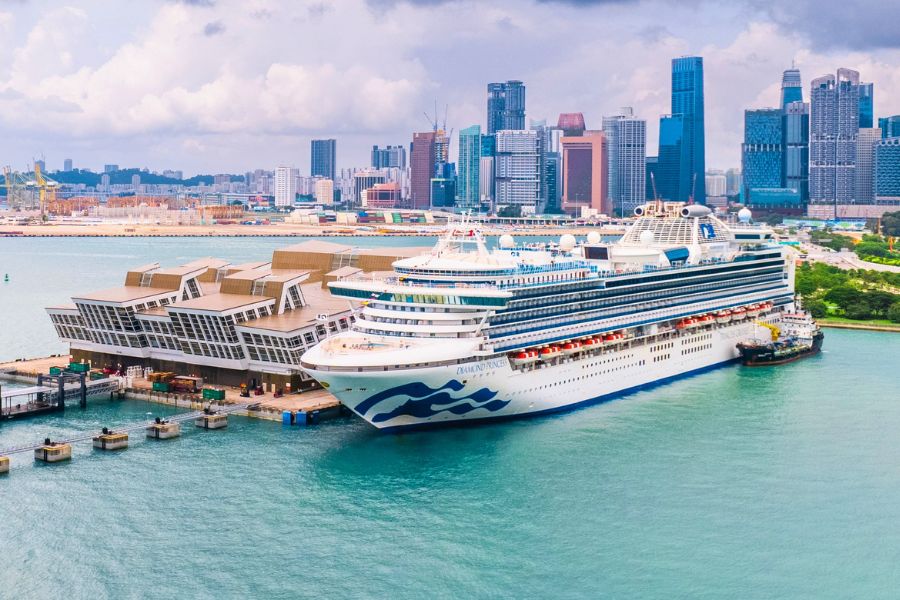 Cruise ship docked near a modern Asian city skyline