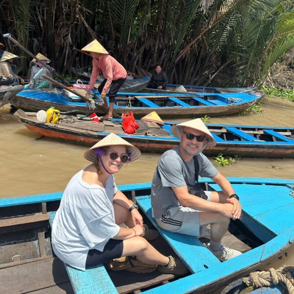 Smiling visitors on a traditional sampan during their Phu My shore excursions