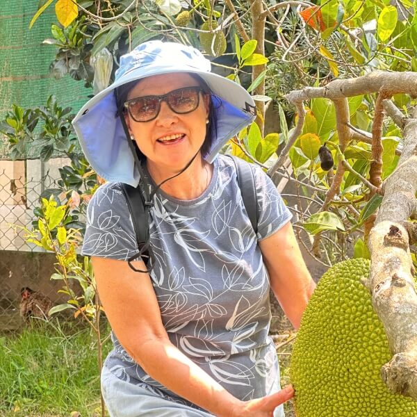 happy customer visit a local home with an orchard in shore excursions from phu my port